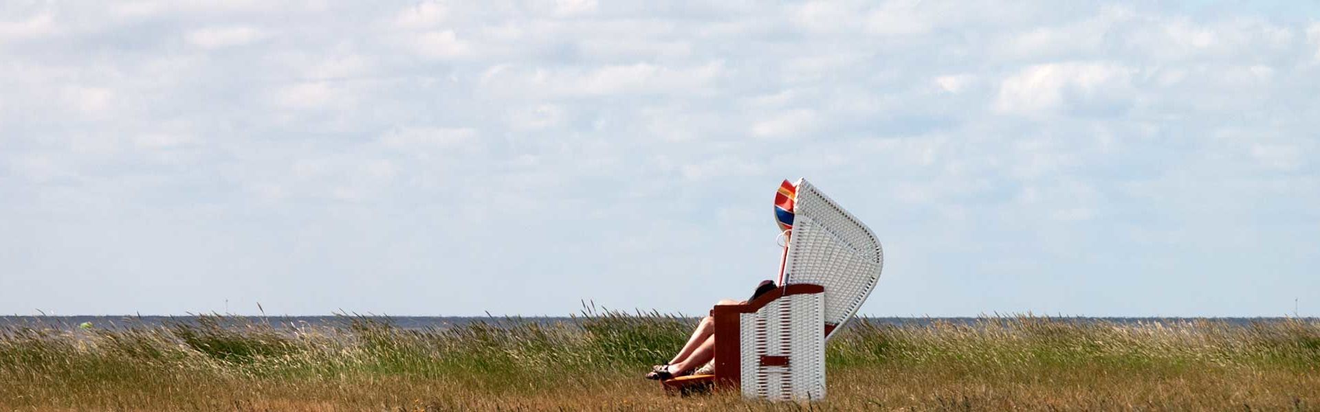 Zwei Personen im Strandkorb am Sommerdeich, Hallig Hooge